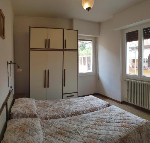 ein Schlafzimmer mit 2 Betten und einem großen Schrank in der Unterkunft Casa Liver Pieve in Tremosine sul Garda