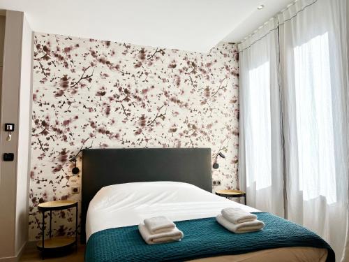 a bedroom with a bed with two towels on it at Le Five Tellier - Blossom in Reims
