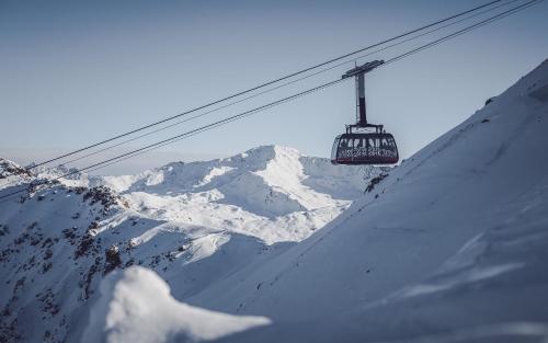 a ski lift going up a snow covered mountain at Club Hotel rooms only - by Mountain Hotels in Davos