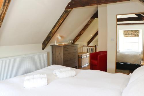 a bedroom with a white bed and a red chair at Town centre apartment with parking in Padstow