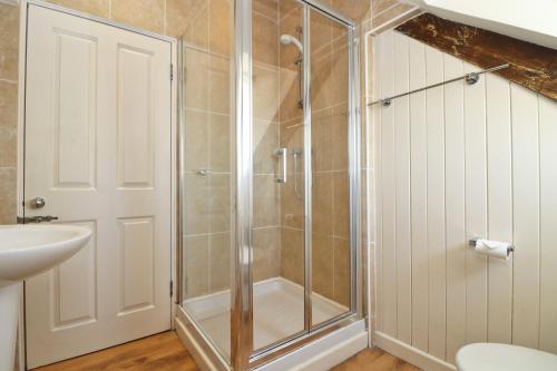a shower with a glass door in a bathroom at Town centre apartment with parking in Padstow