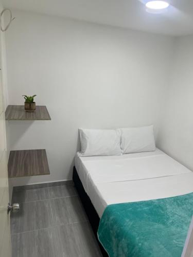 ein weißes Bett in einem kleinen Zimmer mit aarijuanaarijuana in der Unterkunft Apartamento familiar en itagui in Itagüí