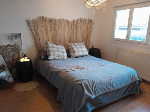 une chambre avec un lit avec une tête de lit et une fenêtre dans l'établissement Charmant logement avec parking gratuit sur place, à Éclaron