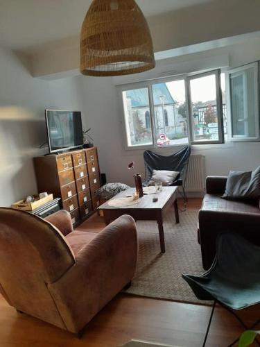 a living room with a couch and a coffee table at Charmant logement avec parking gratuit sur place in Éclaron