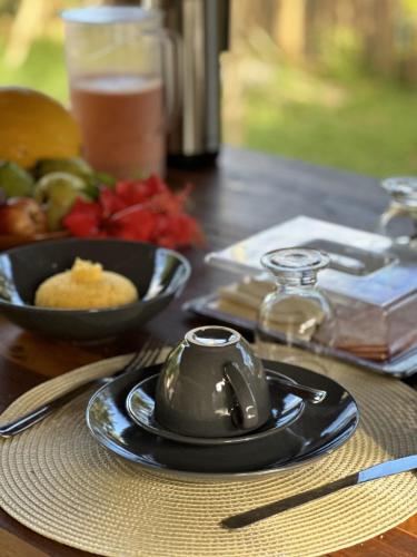 a table with a plate of food and a bowl of fruit at Casa Pé na Areia Noronha in Fernando de Noronha