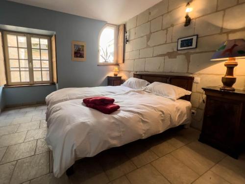 a bedroom with a large bed with white sheets at Maison traditionnelle centre Montsoreau in Montsoreau