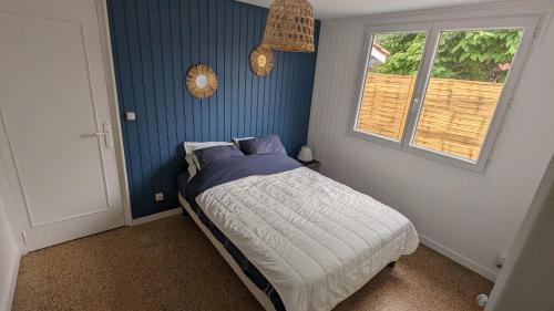 Un dormitorio con una cama con paredes azules y una ventana en Andernos-Maison de centre-ville avec jardin, en Andernos-les-Bains
