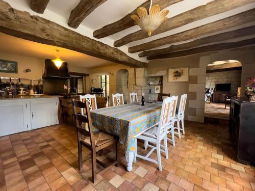 une cuisine et une salle à manger avec une table et des chaises dans l'établissement Maison traditionnelle centre Montsoreau, à Montsoreau