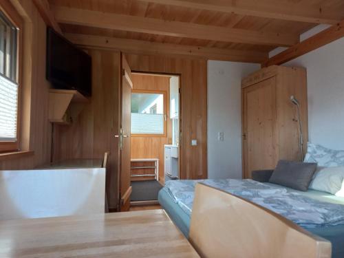 - une chambre avec un lit, une table et une télévision dans l'établissement Ferienwohnung in Schwarzach Vorarlberg, à Schwarzach