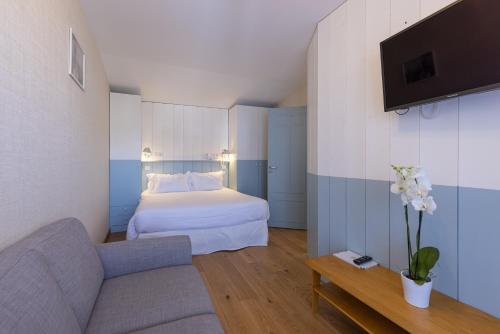 a hotel room with a bed and a couch at La Fr&eacute;gate in Cap-Ferret