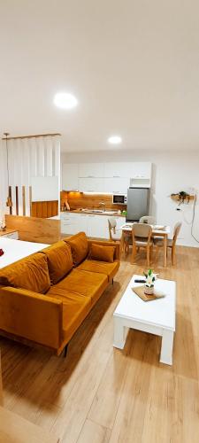a living room with a brown couch and tables at Selvia Apartament in Tirana