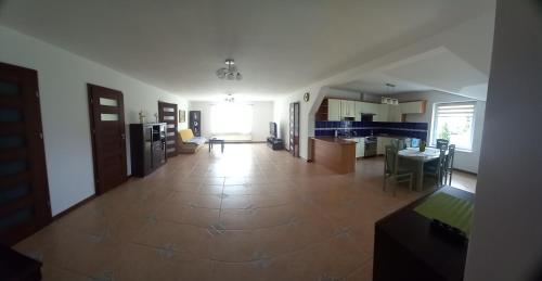 a large room with a kitchen and a living room at Pokoje Vega in Bolszewo