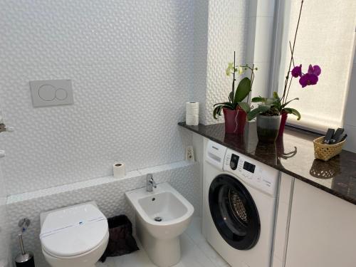 uma casa de banho com um WC e uma máquina de lavar roupa em Apartament lux em Chişinău