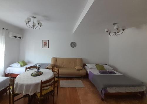 uma sala de estar com um sofá e uma mesa em Apartmani "Rebecca" em Neum