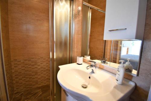 a bathroom with a sink and a shower with a mirror at Apartment Lopar 1 in Lopar