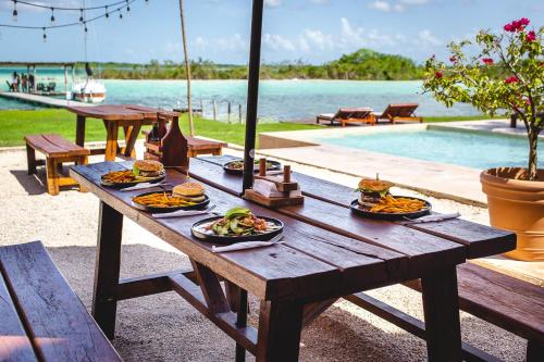 - une table de pique-nique avec de la nourriture à côté de la piscine dans l'établissement Hotel CasaBakal - A pie de Laguna - Bacalar, à Bacalar