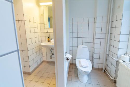 a bathroom with a toilet and a sink at Go Hotel Saga in Copenhagen