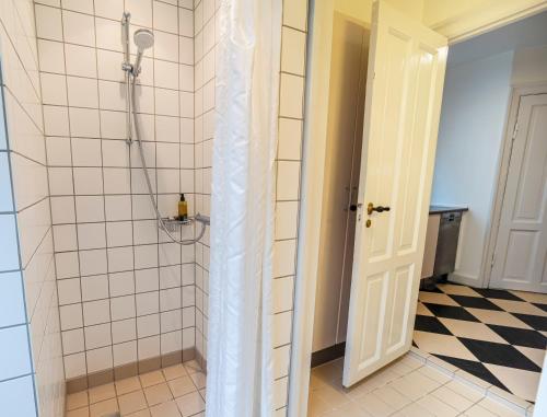 a shower stall in a bathroom with a tile floor at Go Hotel Saga in Copenhagen
