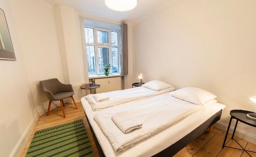 a bedroom with a bed and a chair and a window at Go Hotel Saga in Copenhagen