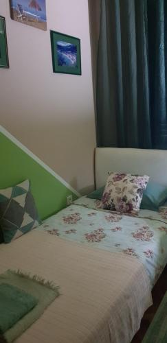 a small bedroom with a bed with a comforter at Guest House Cinderella in Herceg-Novi