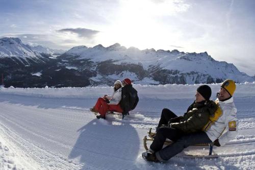 a group of people riding on a sleigh in the snow at La Tgoma - Hotel & Restaurant in Lenz