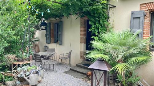 a patio with a table and chairs and a house at 16 Bis-Gîte-Hôtel-Appartement in Marssac-sur-Tarn