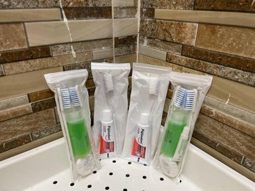 a group of four toothbrushes sitting on a sink at Cozy 3BR House - 8min From City Centre by Sakura 