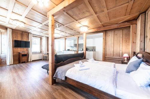 - une chambre avec un grand lit et un canapé dans l'établissement La Tgoma - Hotel & Restaurant, à Lenz