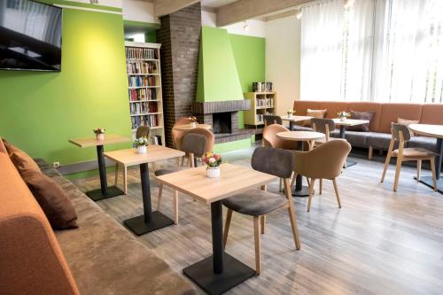 une salle d'attente avec des tables, des chaises et une cheminée dans l'établissement Jugendherberge Hamburg Horner Rennbahn, à Hambourg