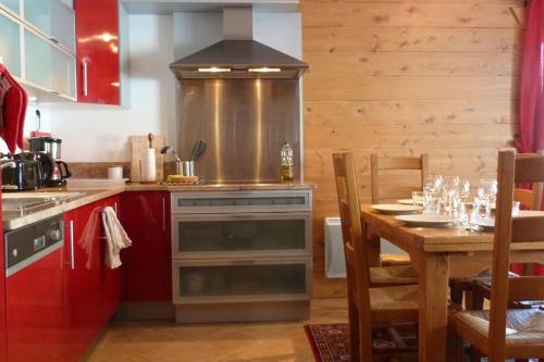 Il comprend une cuisine équipée d'une cuisinière et d'une table à manger. dans l'établissement La Croix - 3 bedroom apartment in Sainte Foy village, à Sainte-Foy-Tarentaise