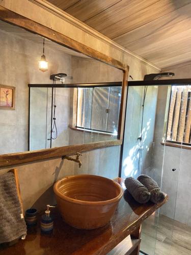 a bathroom with a wooden bowl sink on a counter at Casa Lobo-guará in Alto Paraíso de Goiás
