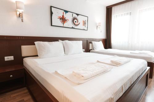 two beds in a hotel room with towels on them at Hotel Centrum Prizren in Prizren
