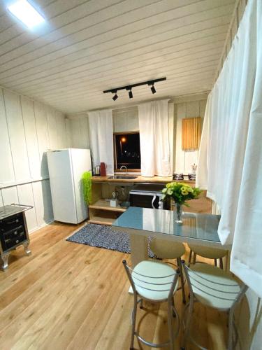 a kitchen with a table and chairs and a refrigerator at Casa de temporada - Recanto da invernada in Urubici