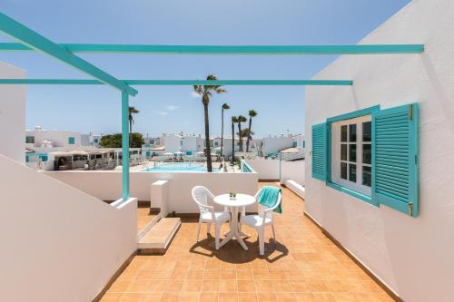 Smy Tahona Fuerteventura في كاليتا ذي فوستي: فناء على طاولة وكراسي على شرفة