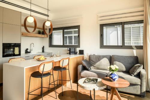 a kitchen and living room with a couch and a table at Balcony Bar Skyline View by Sea N' Rent in Tel Aviv