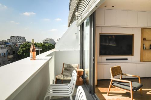 a balcony with chairs and a flat screen tv at Balcony Bar Skyline View by Sea N' Rent in Tel Aviv