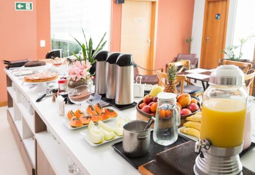 a breakfast buffet with fruit and juice on a counter at Garibaldi Business Hotel in Porto Alegre