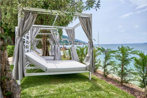 a white swing on the grass near the water at June Stay Lake Garda in Brenzone sul Garda