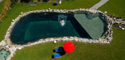 an overhead view of a swimming pool with a red umbrella at Lehenriedl Appartements in Wagrain