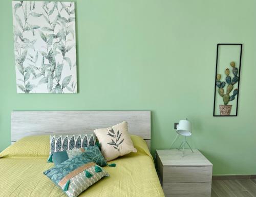 ein Schlafzimmer mit einem Bett mit gelber Tagesdecke in der Unterkunft La Terrazza del Capo in San Vito lo Capo
