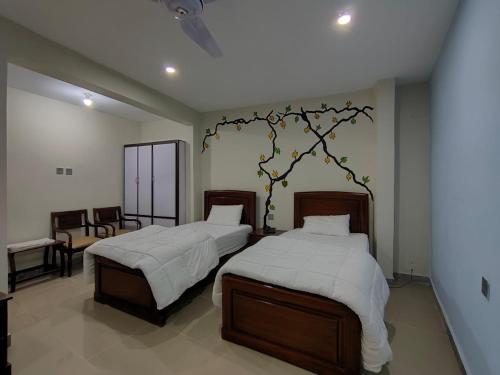 1 dormitorio con 2 camas con sábanas blancas en Alpha Hotel & Restaurant, en Skardu