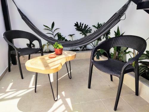 a group of chairs and a table with a plant at Bona Vida Hostel in Ríohacha