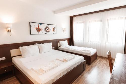 a hotel room with two beds and a window at Hotel Centrum Prizren in Prizren