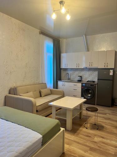 Habitación con cama, sofá y mesa. en Apartments NITA en Batumi