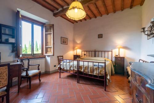 ein Schlafzimmer mit einem Bett und einem Stuhl in einem Zimmer in der Unterkunft Appartamento Fattoria in Laterina