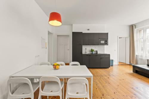 a kitchen and dining room with a white table and chairs at Apartments elPilar Friedrichshain in Berlin