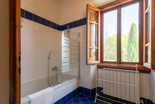 ein Bad mit einer Dusche, einer Badewanne und einem Fenster in der Unterkunft Appartamento Fattoria in Laterina