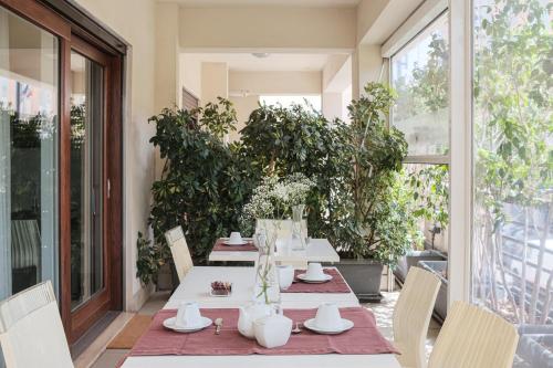 una mesa y sillas en un patio con plantas en Maison R Boutique en Reggio Calabria