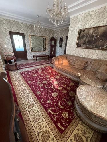 a living room with a couch and a large rug at Тумар in Osh