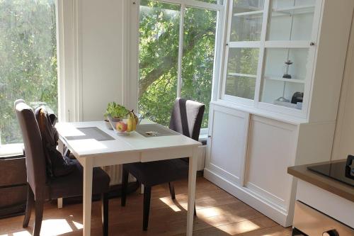 a white table and chairs in a room with a window at Amsterdam - Bright, canal-side, central, renovated 1BR in Amsterdam